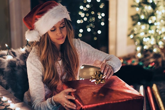 Woman wrapping present while dealing with holiday stress
