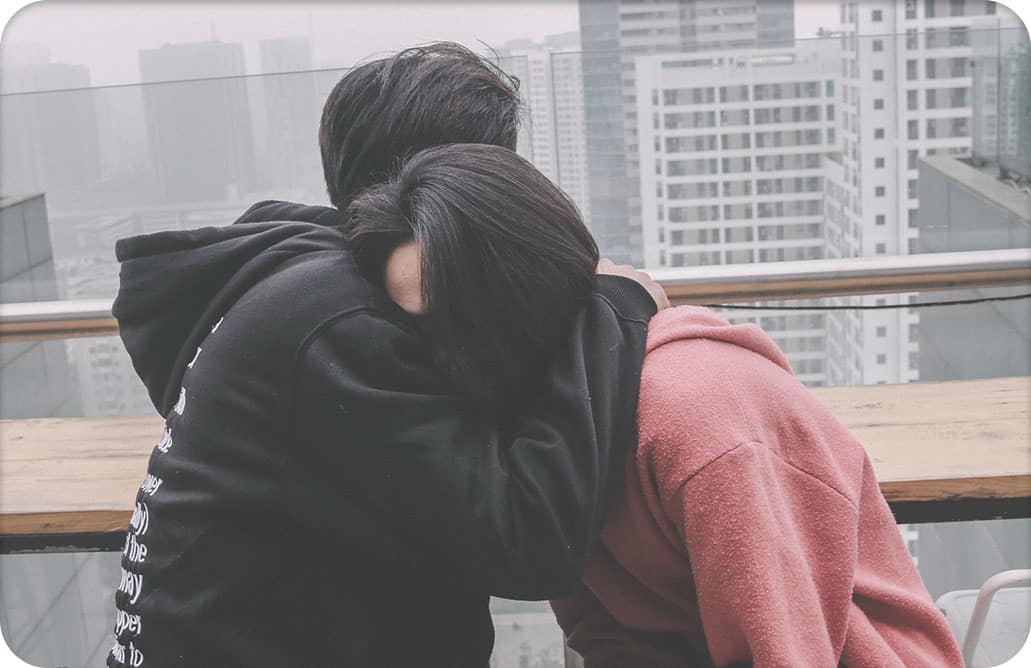 Man hugging woman on balcony