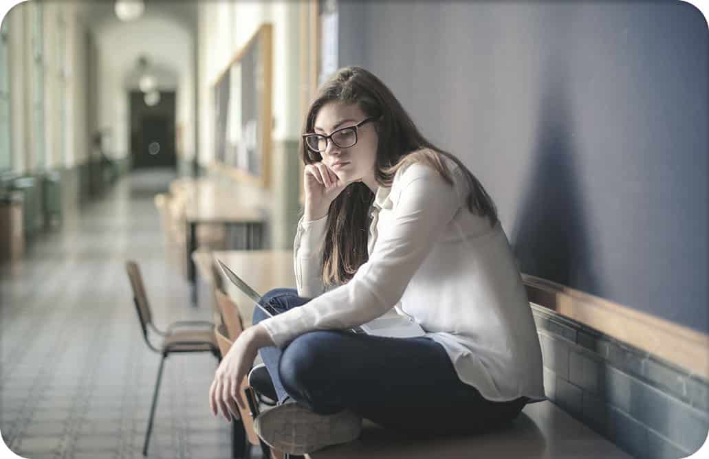 girl sitting on desk in hallway